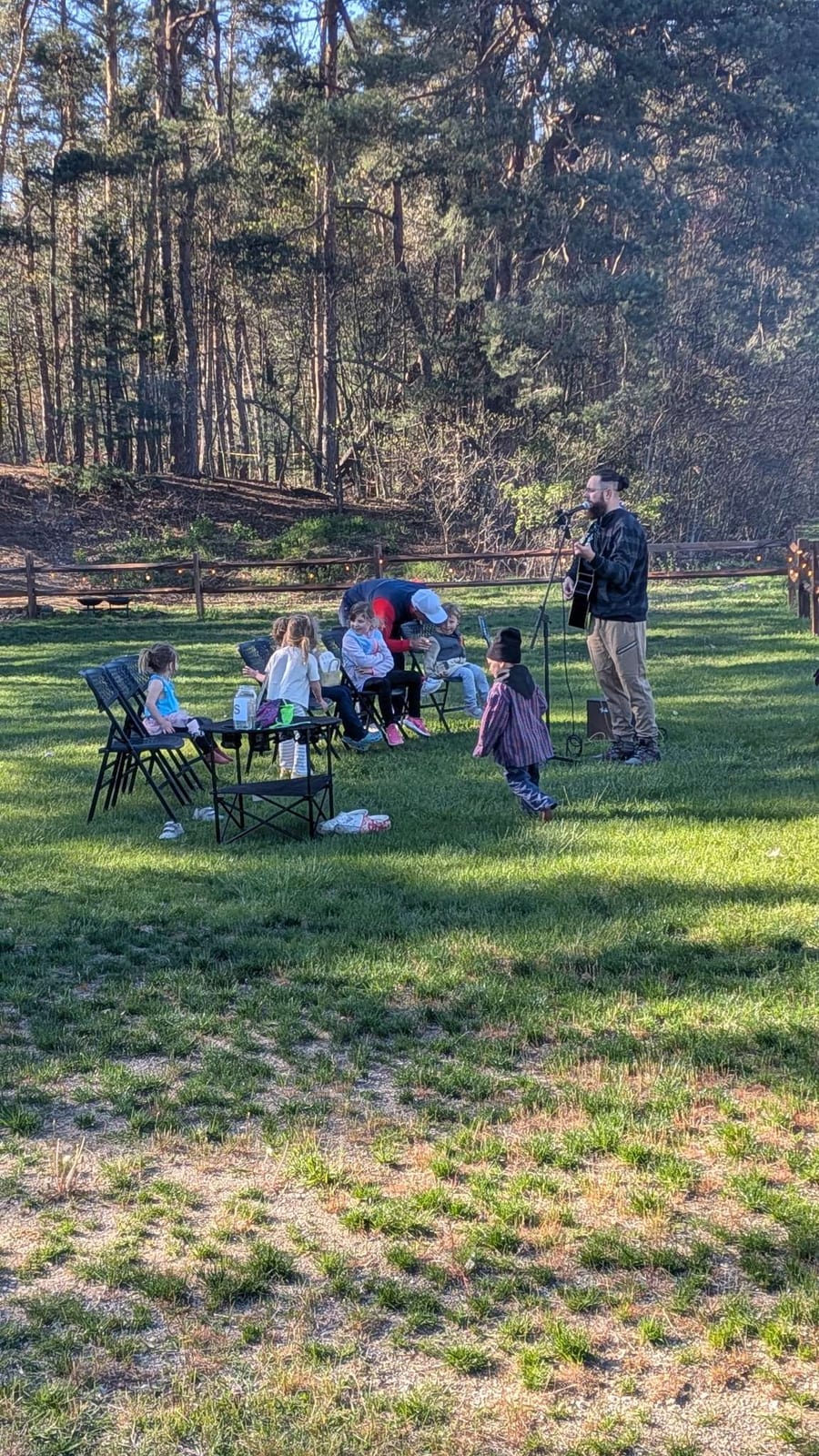 Eric Gilliland performing live for a small outdoor audience of families and kids